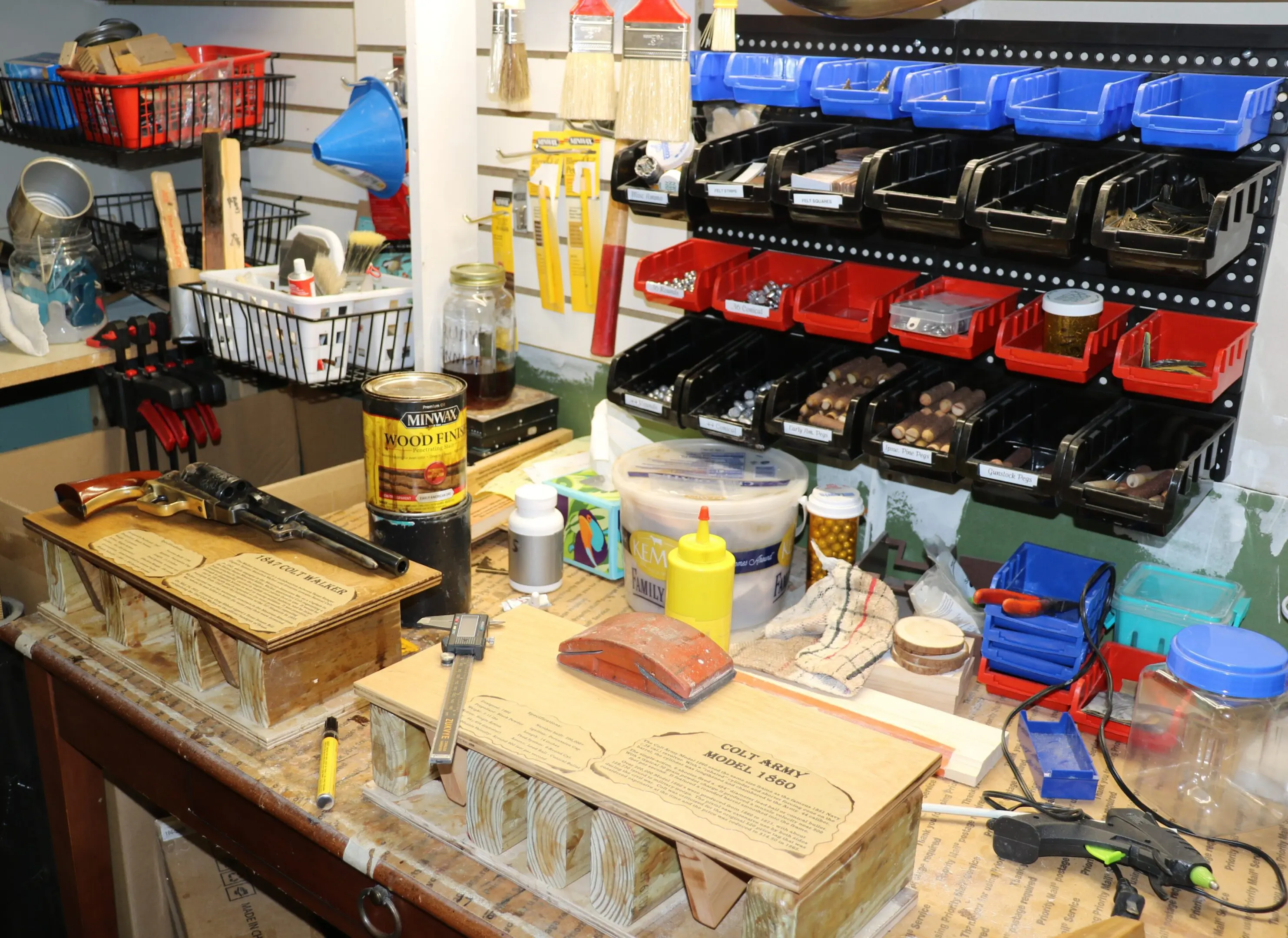 Cluttered workshop workbench with tools and bins